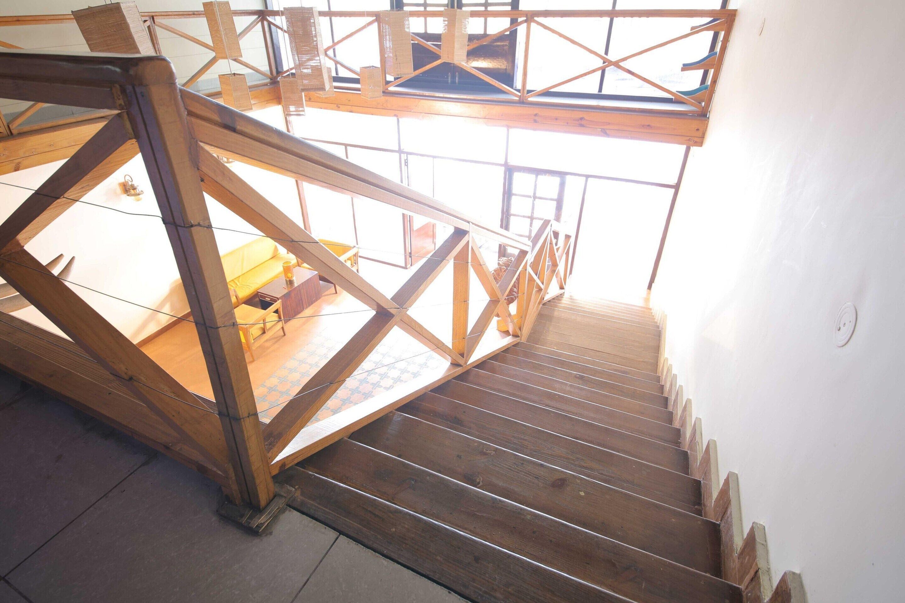 Un escalier en bois mène à une mezzanine d’où l’on peut admirer l’intérieur.
