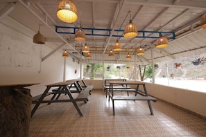 A restaurant interior with high ceilings, wicker pendant lighting, and outdoor views. - Premium Dome With Hill and River Viewhotel Ribera (Dehradun)