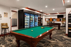 Une table de billard avec des billes, une queue de billard et un porte-billes.