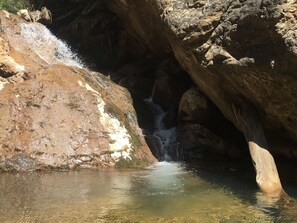 Une formation rocheuse naturelle avec une petite cascade et de l’eau claire.