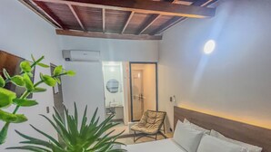 Une chambre d’hôtel équipée d’un lit, d’une chaise, d’un lavabo et d’un appareil de climatisation.