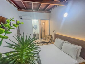 A hotel room with a bed, a chair, a sink, and an air conditioning unit. - Cumbiana Loft in Provenza by Nowa (Medellín)