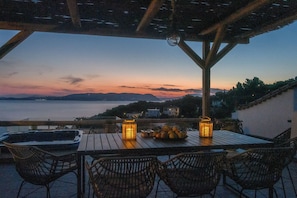 An outdoor seating area with wicker chairs, a wooden table, and two lanterns.