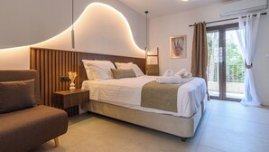 Una habitación de hotel moderna con una cama grande, un sofá, una mesita de noche y vistas al exterior.