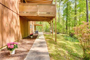 A wooden building with a covered porch and a concrete pathway leading to a vehicle. - Tranquil 1-bedroom apartment with AC in charming Toccoa (Toccoa)