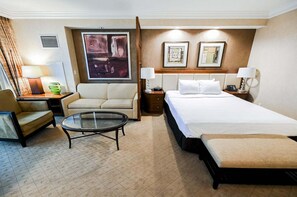 A hotel room with a bed, a sofa, a chair, a small table, and two bedside lamps. - Strip View Studio • No Resort Fee • Free Parking B18P1 (Las Vegas)