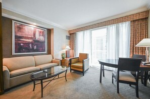 A hotel room with a sofa, a chair, a small table, a lamp, and a painting on the wall. - Strip View Studio • Balcony • No Resort Fee C6T1 (Las Vegas)