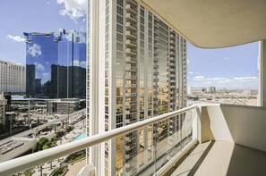 A high-rise building with multiple balconies, a clear view of a cityscape, and a pool area in the foreground. - SVS: Strip View Balcony | Signature at MGM (Las Vegas)