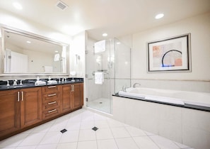Un baño moderno con un espejo grande, una bañera y un box de ducha de vidrio.