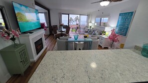 Ein modernes Wohnzimmer mit Fernseher, einer Sitzecke und Blick auf den Ozean.