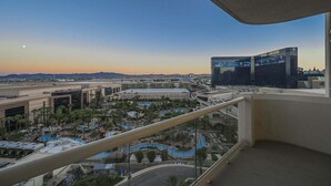 Vista da un balcone su una zona turistica con piscina, palme e un casinò.