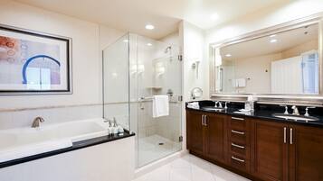 A modern bathroom with a glass-enclosed shower, a large mirror, and a bathtub.