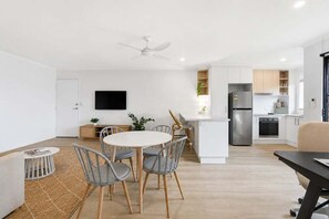 A modern kitchen with white cabinets, a stainless steel refrigerator, and a built-in oven. - Riviera - Stylish Interiors, Sleeps 4,  Walk to Beach (Coffs Harbour)