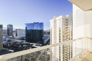 A high-rise hotel with a modern glass facade, multiple balconies, and a view of the surrounding cityscape. - SVS: PH Floor Strip View Balcony | Signature at MGM (Las Vegas)