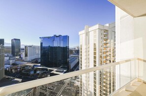 A high-rise hotel with a modern glass facade, multiple balconies, and a view of the surrounding cityscape. - SVS: PH Floor Strip View Balcony | Signature at MGM (Las Vegas)