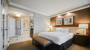 A hotel room with a bed, bedside tables, a bench, a wardrobe, and a bathroom visible through an open door. - SVS: Studio | Signature at MGM (Las Vegas)
