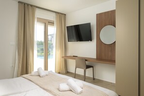 A hotel room with a bed, a desk, a chair, a TV, and a window with curtains. - Villa ViriBora (Istria - Loborika) (Loborika)