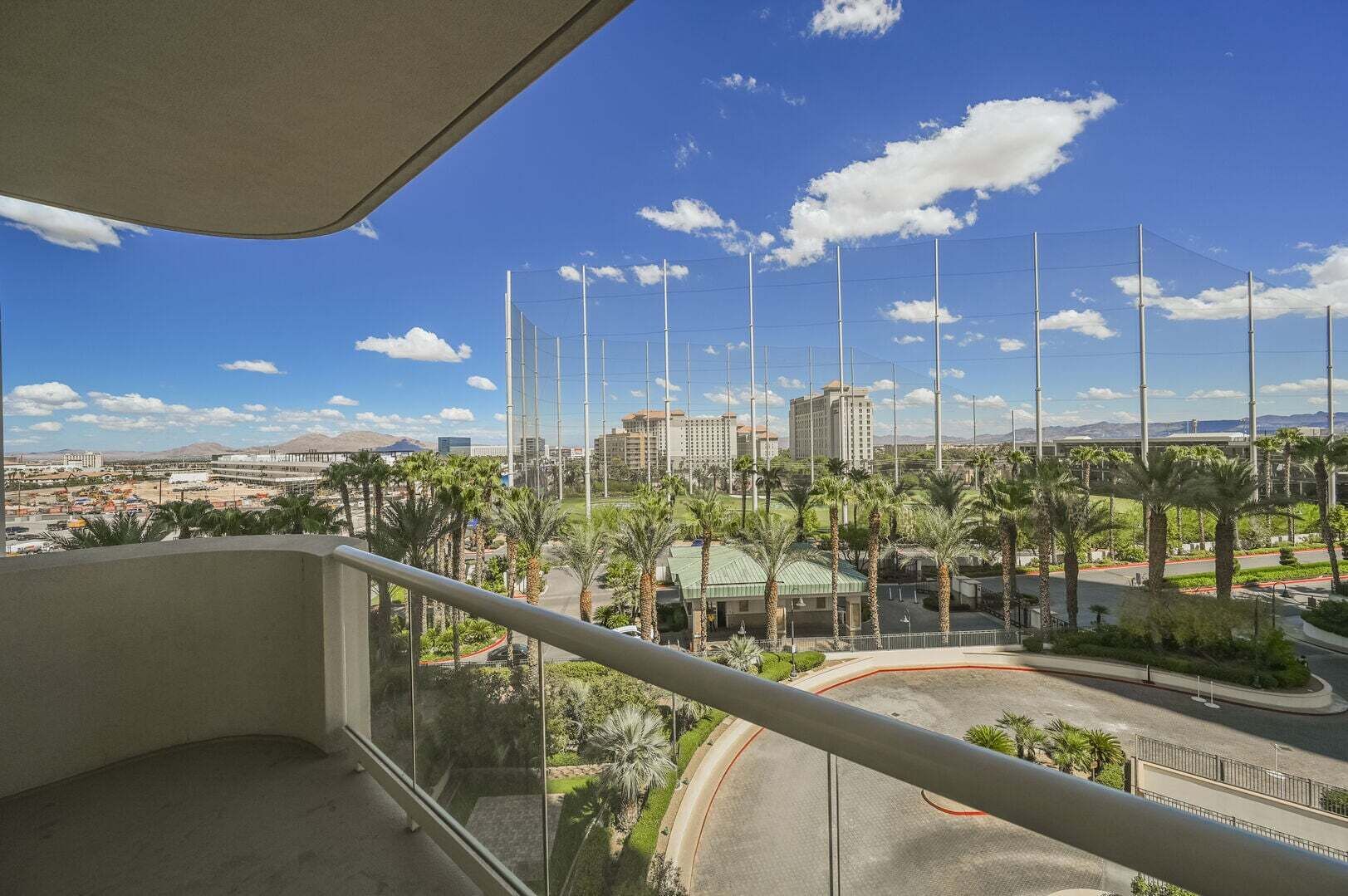 Ein Balkon mit Blick auf eine Stadtlandschaft, einschließlich Gebäude und Palmen.