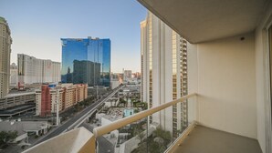Un grattacielo con facciata in vetro, un parcheggio e una vista libera sullo skyline circostante.