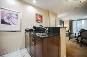 Ein Hotelzimmer mit Küchenzeile, Essbereich und Blick auf die Stadt.