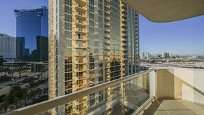 Un immeuble de grande hauteur doté d’une façade en verre, de nombreux balcons et offrant une vue dégagée sur le paysage urbain.