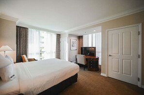 A hotel room with a large bed, a desk with a television, and a door. - 1BD/2BA • Strip View • Balcony • No Resort Fee F11K2 (Las Vegas)