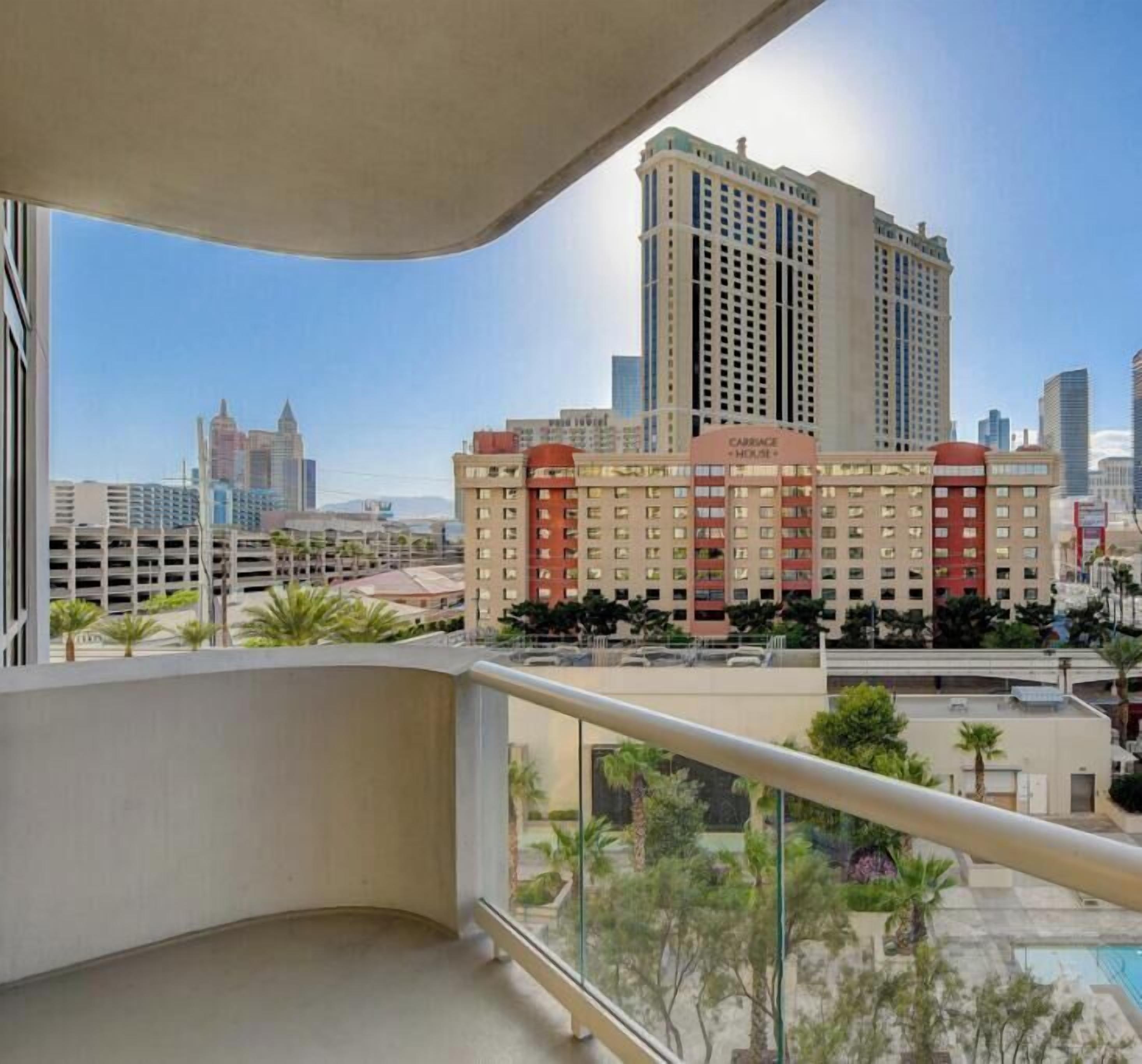 Een hoog hotel met uitzicht op de skyline, inclusief andere gebouwen en een zwembad.