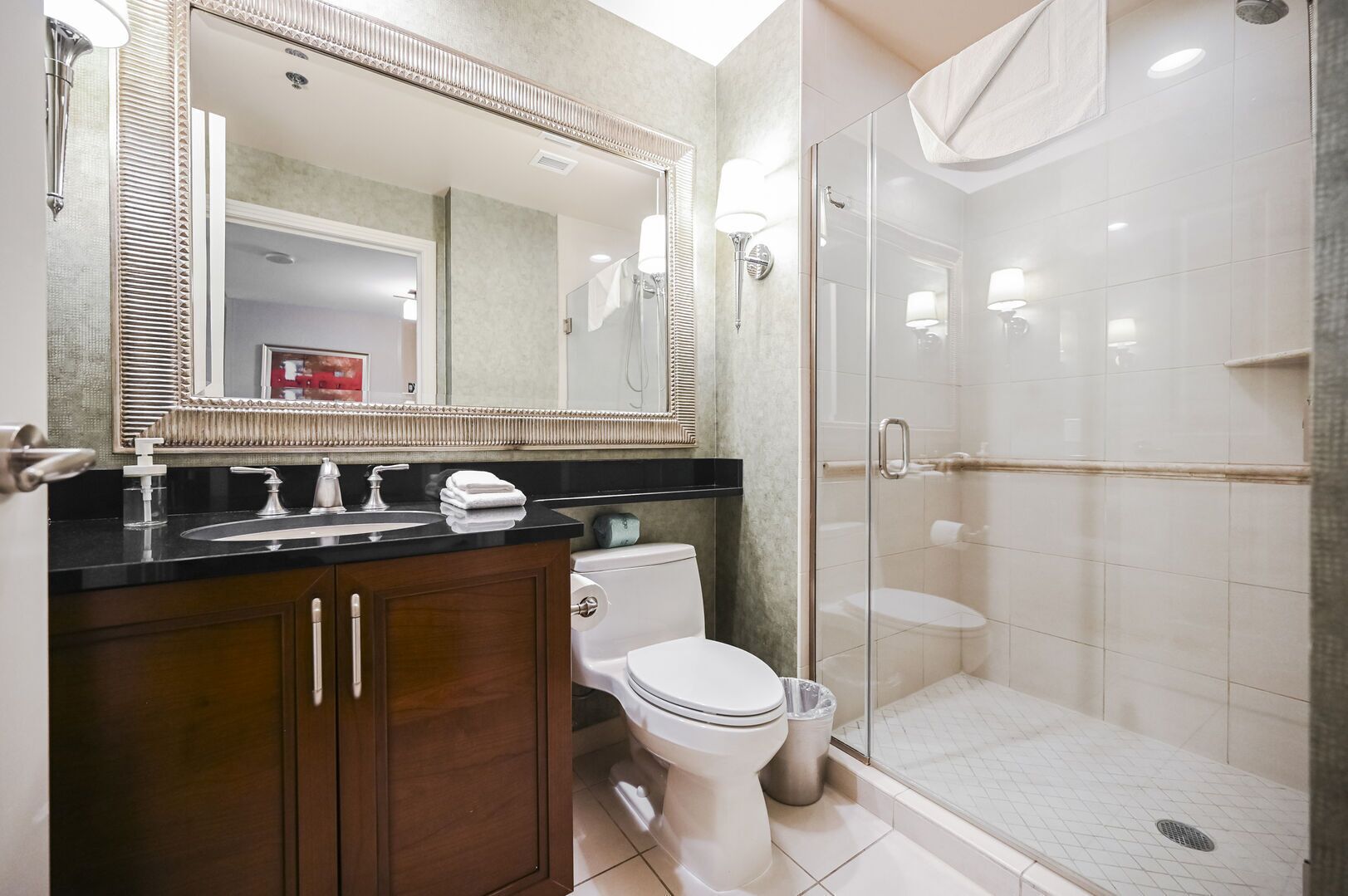 Een moderne badkamer met een douche met glazen wand, een wastafelmeubel en een toilet.