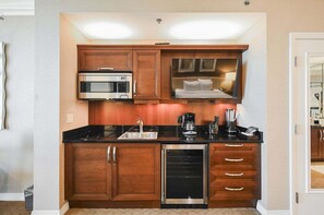 A compact kitchen with a microwave, coffee maker, and dishwasher. - SVS: Strip View Studio | Signature at MGM (Las Vegas)