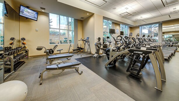 A gym with treadmills, weight machines, and dumbbells. - SVS: One Bedroom | Strip View Balcony | MGM Signature (Las Vegas)