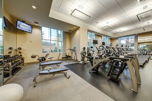 Et fitnesscenter med løbebånd, træningsmaskiner og håndvægte.