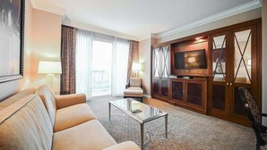 A hotel room with a sofa, a coffee table, a TV, and a large window with curtains. - 1BD/2BA • Balcony • No Resort Fee • Free Parking E26A3 (Las Vegas)