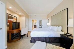Ein Hotelzimmer mit Bett, Nachttisch, Lampe, Fernseher und Schreibtisch mit Stuhl.