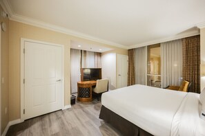 A hotel room with a bed, a desk with a chair, a television, and a mirror. - SVS: PH Floor One Bedroom | Balcony | Signature at MGM (Las Vegas)