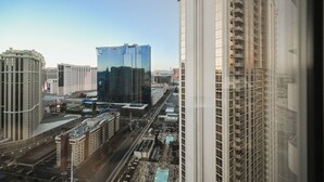 A high-rise building with a modern glass facade, surrounded by other tall buildings, and a busy street with vehicles. - SVS: Strip View Studio | Signature at MGM (Las Vegas)