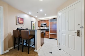 A compact kitchen with a central island, wooden cabinets, and a microwave. - 1BD/2BA • Balcony • No Resort Fee • Free Parking E12V3 (Las Vegas)