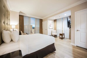 A hotel room with a large bed, a chair, a small table, and a door. - Remodeled 1BD/2BA • Strip View • Balcony • No Resort Fee F14Q3 (Las Vegas)
