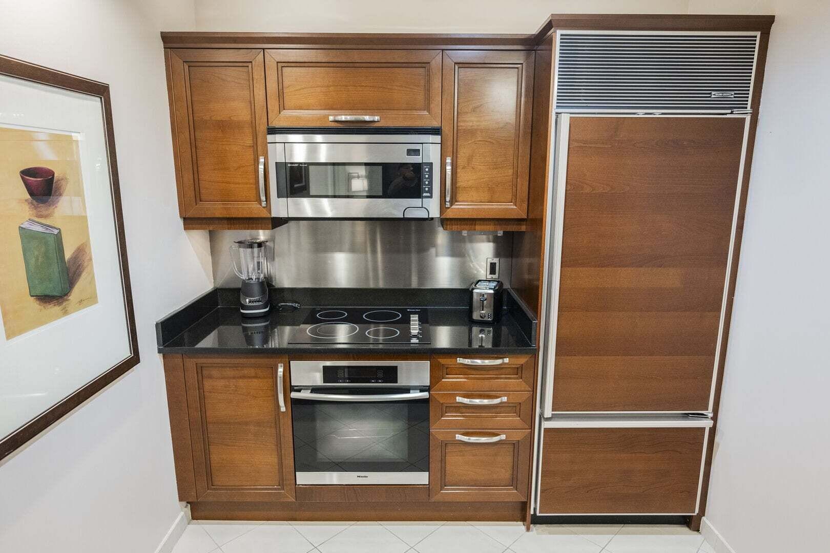 Eine kleine Küche mit Mikrowelle, Herd, Backofen und Kühlschrank.