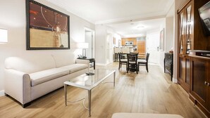 Un salon moderne comprenant un canapé, une table basse et un coin repas avec des chaises.
