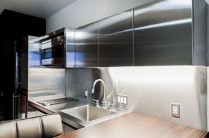Eine moderne Küche mit Edelstahlgeräten, einem eingebauten Backofen und einem eleganten Wasserhahn.