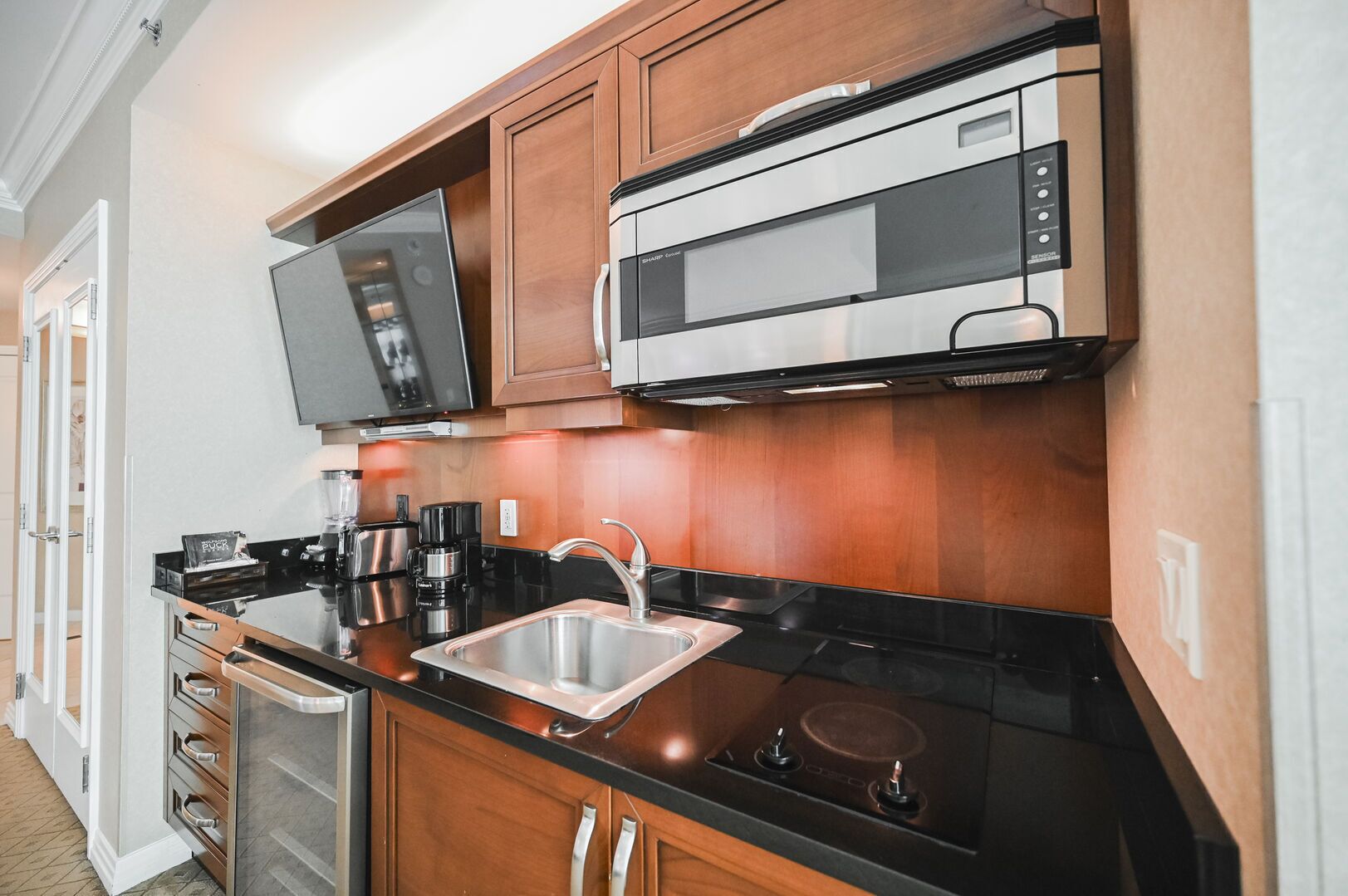 Una cocina moderna con microondas, estufa, fregadero y armarios.