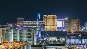 A cityscape at night with illuminated buildings, including a prominent Ferris wheel and several high-rise hotels. - SVS: PH Floor Sphere Strip View Balcony | Signature at MGM (Las Vegas)
