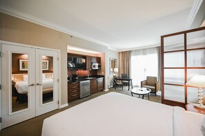 A hotel room with a large bed, a kitchenette, a dining area, and a separate seating area. - PH Floor Studio • Strip View • Balcony • No Resort Fee D31M3 (Las Vegas)