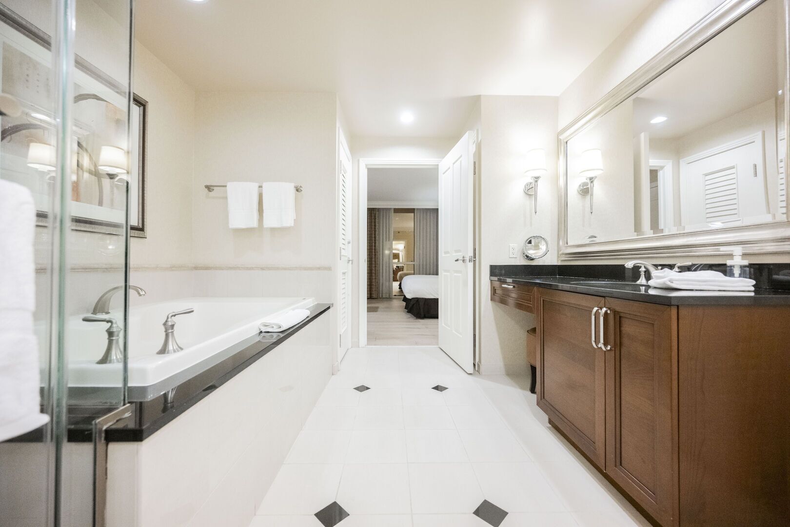 A modern bathroom with a glass shower enclosure, a double sink vanity, and a large mirror.