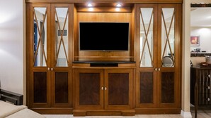 Eine Holz-Unterhaltungsanlage mit Flachbildfernseher, integrierten Regalen und verspiegelten Türen.