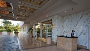 A hotel lobby with a reception desk, marble walls, and a glass entrance. - SVS: Strip View Studio | Resort Pool & Gym | Signature at MGM (Las Vegas)