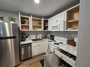 A modern kitchen with white cabinetry, stainless steel appliances, and a built-in wine cooler. - Ultra Clean 2BT w/2 Kings Near MCI and T-Mobile Center (Riverside)