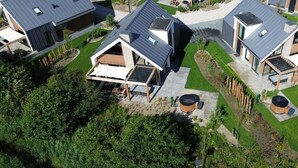 A residential area with modern houses featuring flat roofs, large windows, and outdoor seating areas. - Duinvilla Wellness 5 (De Cocksdorp)