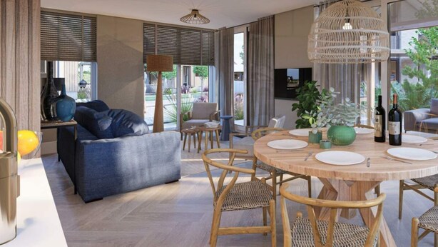 A modern living room with a sofa, dining table, chairs, and a large window. - Duinvilla Wellness 5 (De Cocksdorp)