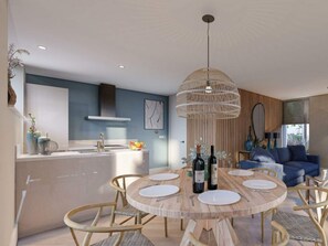 Eine moderne Küche mit Kochinsel, ein Essbereich mit rundem Holztisch und ein Wohnbereich mit blauem Sofa.